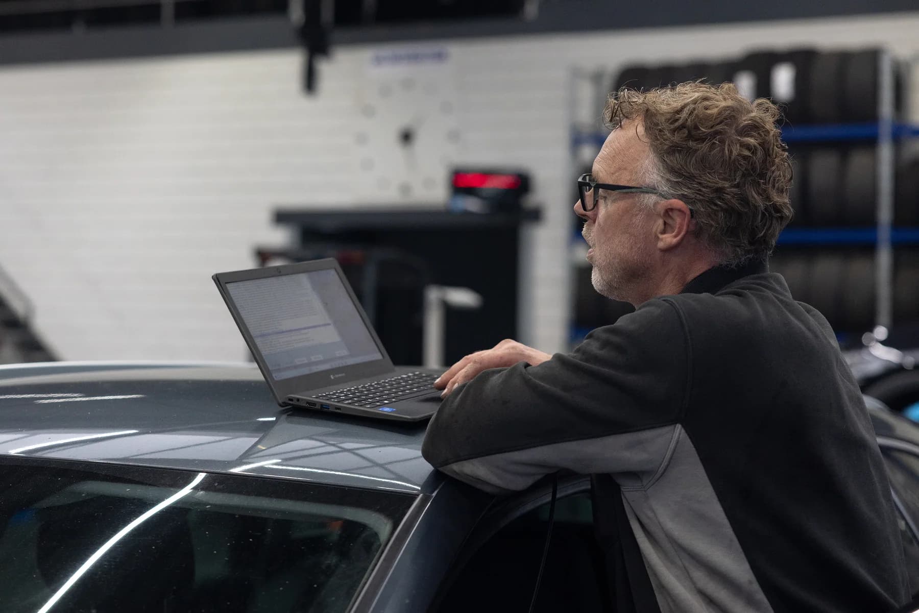 Monteur van Garage Wursten onderzoekt een auto met een diagnoselaptop
