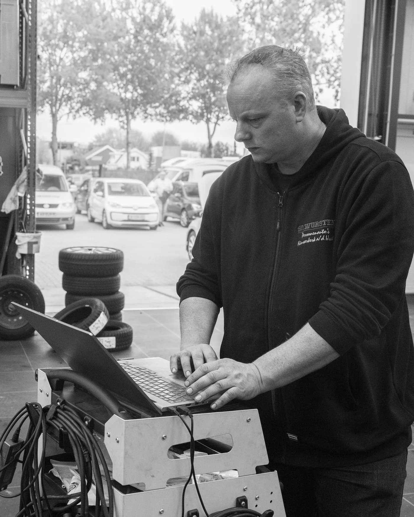 Monteur van Garage Wursten werkt met een diagnoselaptop op een werkplaatswagen